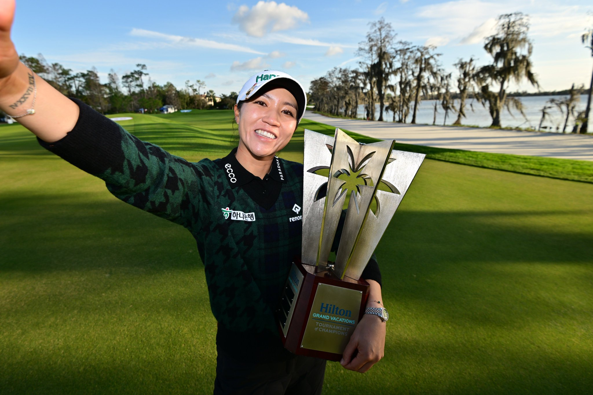 Lydia Ko holding Hilton Grand Vacations TOC trophy made by Malcolm DeMille
